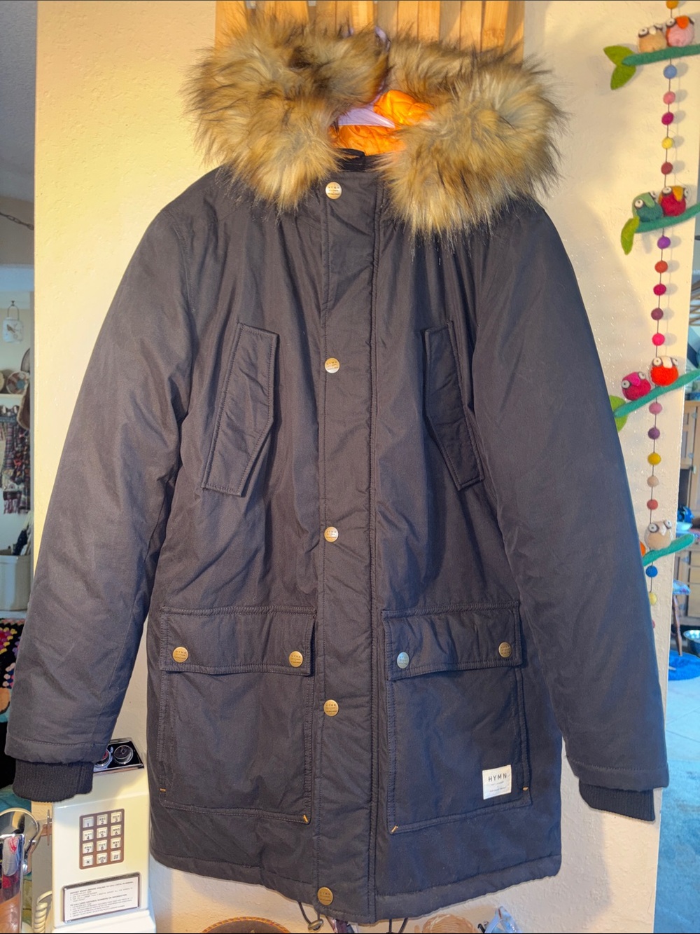 EUC HYMN parka featuring a faux fur hood trim and metal snap fasteners